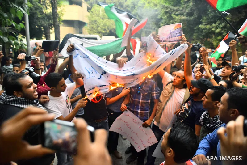 Egyptian protesters burn a mock Israeli flag during a demonstration expressing solidarity with Palestinians, outside the Palestinian Embassy in Cairo, October 16, 2015. According to local reports a group of protesters ex...