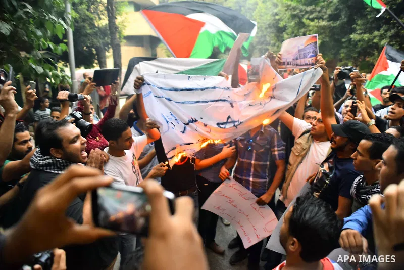 Egyptian protesters burn a mock Israeli flag during a demonstration expressing solidarity with Palestinians, outside the Palestinian Embassy in Cairo, October 16, 2015. According to local reports a group of protesters ex...