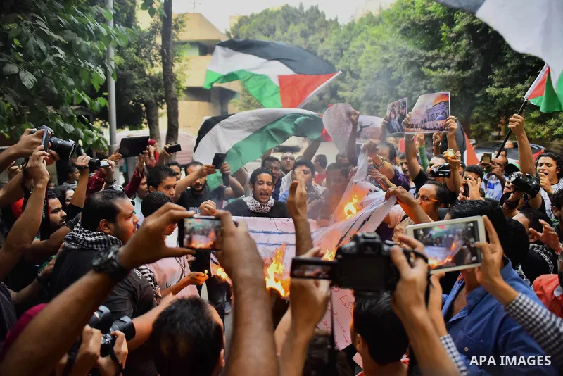 Egyptian protesters burn a mock Israeli flag during a demonstration expressing solidarity with Palestinians, outside the Palestinian Embassy in Cairo, October 16, 2015. According to local reports a group of protesters ex...