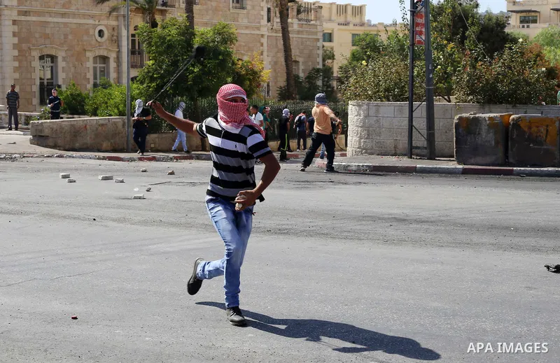 A Palestinian protester hurls stones towards Israeli security forces during clashes at the main entrance of the West Bank city of Bethlehem on October 16, 2015. The unrest that has engulfed Jerusalem and the occupied Wes...