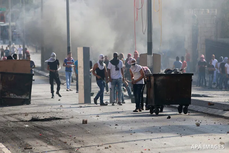 Palestinian protesters throw stones towards Israeli security forces during clashes at the main entrance of the West Bank city of Bethlehem on October 16, 2015. The unrest that has engulfed Jerusalem and the occupied West...