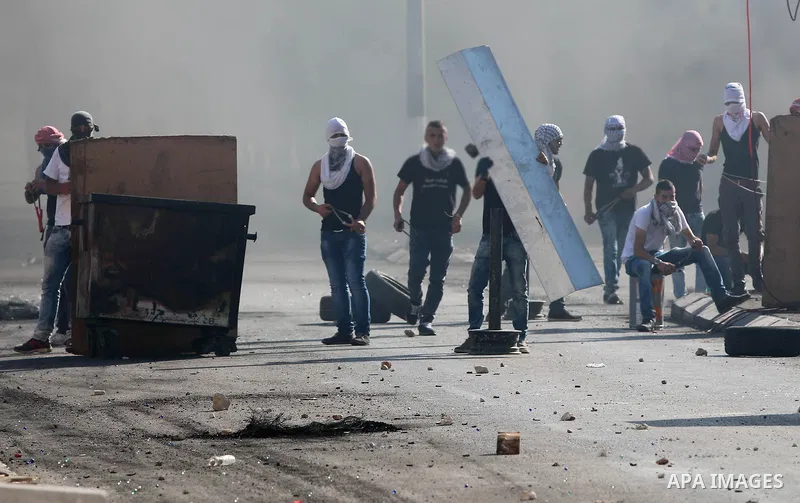 Palestinian protesters throw stones towards Israeli security forces during clashes at the main entrance of the West Bank city of Bethlehem on October 16, 2015. The unrest that has engulfed Jerusalem and the occupied West...