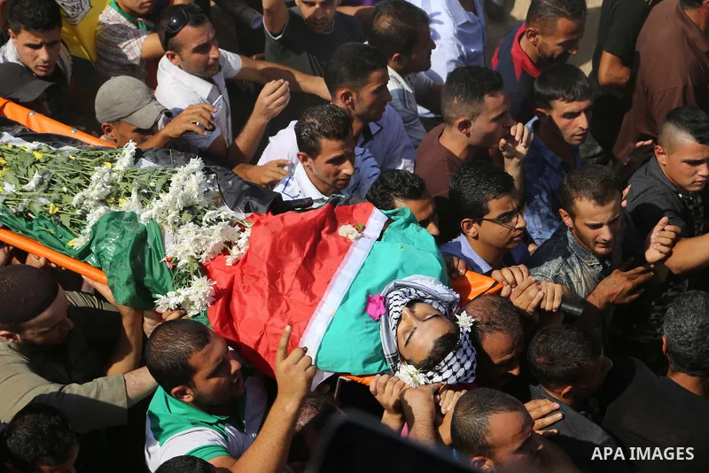 Relatives carry the body of Palestinian Eyad Awawda, who while disguised as a news photographer, stabbed and wounded a soldier at an entrance to the West Bank settlement of Kiryat Arba before being shot dead, during his...
