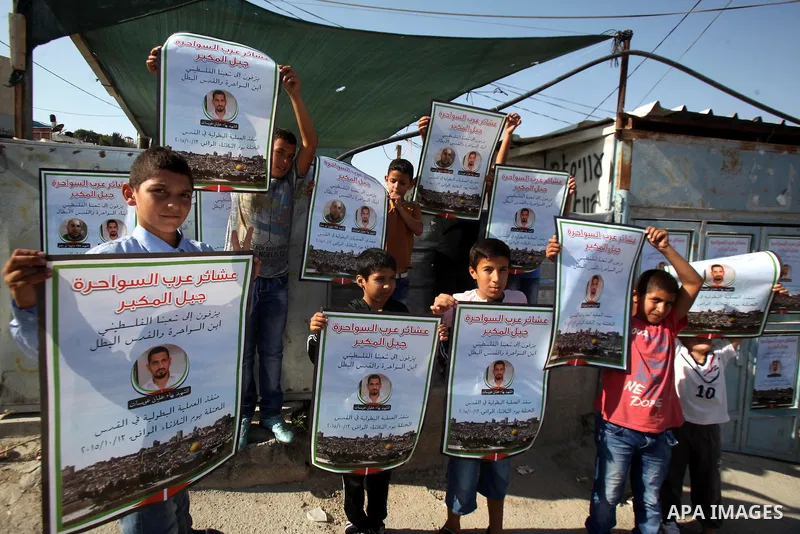 Relatives of Palestinian Bahaa Alian, who was killed by Israeli security forces, hold his picture at their house in Jabal al-Mukaber neighborhood, southern Jerusalem, on October 17, 2015. A wave of stabbings that hit Isr...