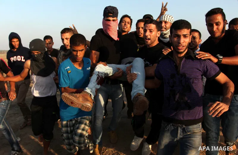 A wounded Palestinian protester is evacuated after he was shot by Israeli troops during clashes near the border between Israel and Central Gaza Strip east of Bureij October 17, 2015. At least 40 Palestinians and seven Is...