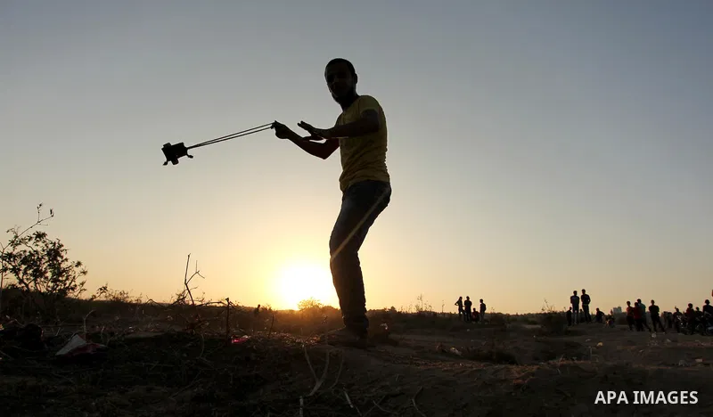 Palestinian protesters hurl stones at Israeli troops during clashes near the border between Israel and Central Gaza Strip east of Bureij on October 17, 2015. At least 40 Palestinians and seven Israelis have died in more...