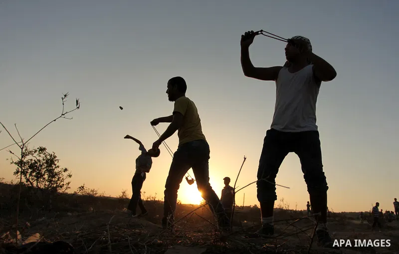 Palestinian protesters hurl stones at Israeli troops during clashes near the border between Israel and Central Gaza Strip east of Bureij on October 17, 2015. At least 40 Palestinians and seven Israelis have died in more...
