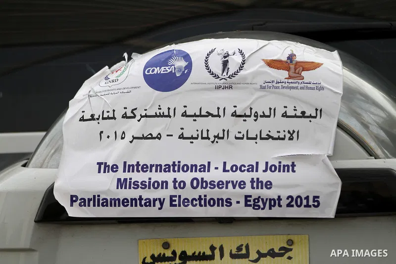 International Observers arrive at the entrance of a polling center, before polls open, during the first round of the parliamentary election in Cairo, Egypt, Sunday, Oct. 18, 2015. Photo by Amr Sayed