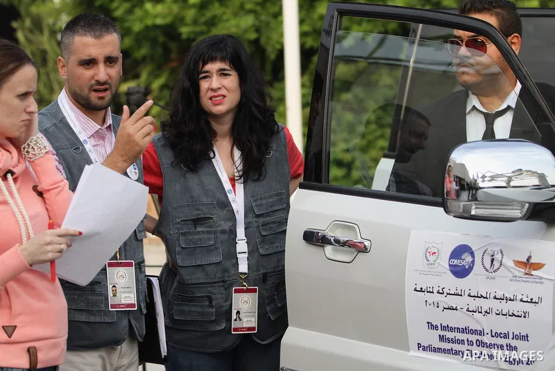International Observers arrive at the entrance of a polling center, before polls open, during the first round of the parliamentary election in Cairo, Egypt, Sunday, Oct. 18, 2015. Photo by Amr Sayed