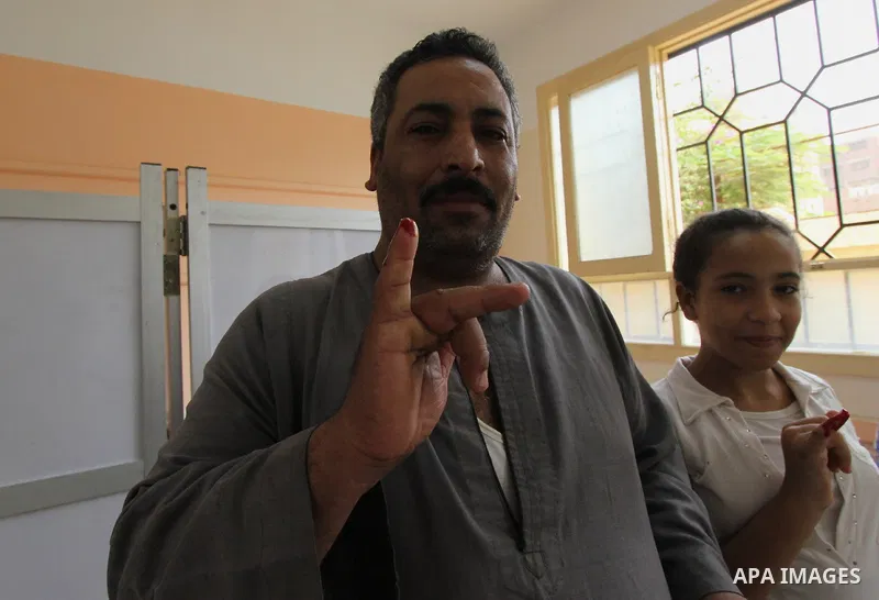 Egyptian men cast their ballot in the Egyptian parliamentary elections at a polling station in the Al-Ayyat area of Giza, 40kms (25 miles) southwest of Cairo, on October 18, 2015. Polling opened earlier in the day in Egy...