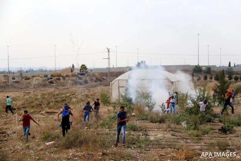 Palestinian protesters run for cover from tear gas fired by Israeli security forces during clashes in the West Bank town of Tulkarm, October 18, 2015. Tensions in the region run high after weeks of street violence with t...