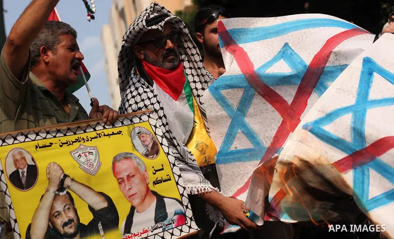 Palestinians burn an Israeli flag during in an anti-Israel protest in front of Red cross office, in Gaza city, on Oct. 19, 2015. Israel pressed ahead with major security measures after five more stabbing incidents, while...