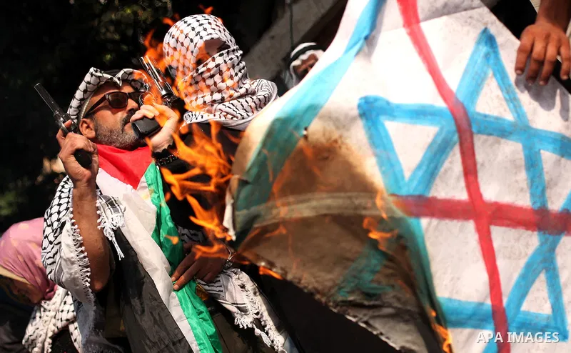 A Palestinian woman burns an Israeli flag during in an anti-Israel protest in front of Red cross office, in Gaza city, on Oct. 19, 2015. Israel pressed ahead with major security measures after five more stabbing incident...