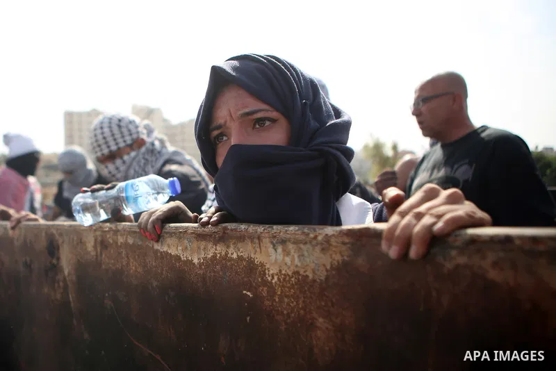 A female Palestinian protester pushes a trash container during clashes with Israeli security forces near the Jewish settlement of Beit El, near the West Bank city of Ramallah October 20, 2015. Triggered by Israeli incurs...