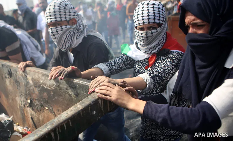 Female Palestinian protesters push a trash container during clashes with Israeli security forces near the Jewish settlement of Beit El, near the West Bank city of Ramallah October 20, 2015. Triggered by Israeli incursion...