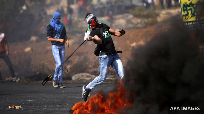 A Palestinian protester uses a sling shot to throw stones during clashes with Israeli security forces near the Jewish settlement of Beit El, near the West Bank city of Ramallah October 20, 2015. Triggered by Israeli incu...