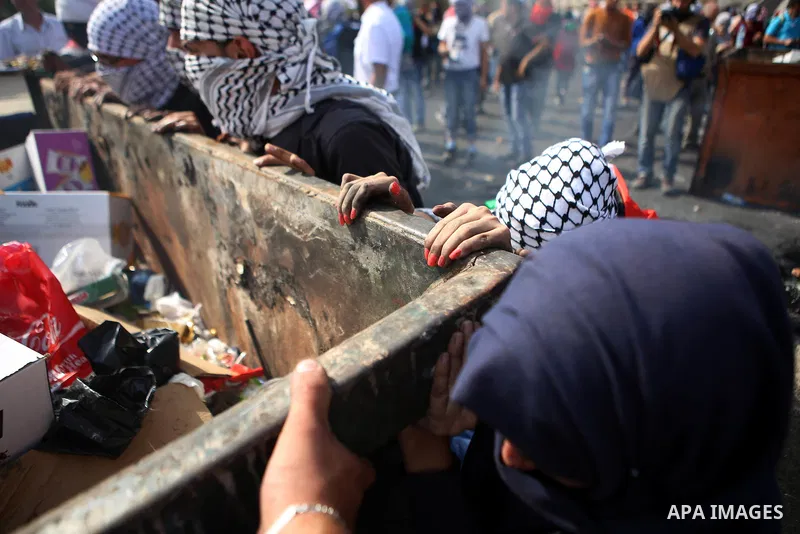 Palestinian protesters push a trash container during clashes with Israeli security forces near the Jewish settlement of Beit El, near the West Bank city of Ramallah October 20, 2015. Triggered by Israeli incursions into...