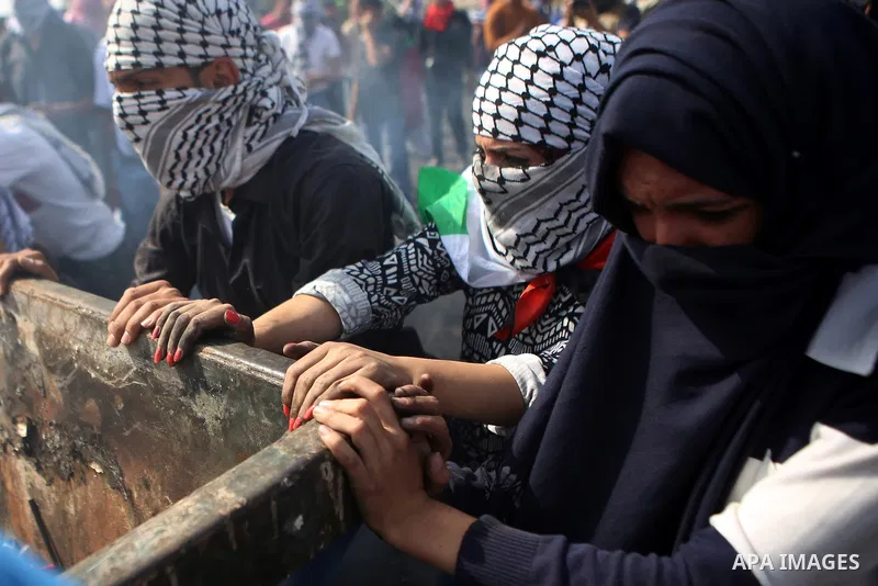 Palestinian protesters push a trash container during clashes with Israeli security forces near the Jewish settlement of Beit El, near the West Bank city of Ramallah October 20, 2015. Triggered by Israeli incursions into...