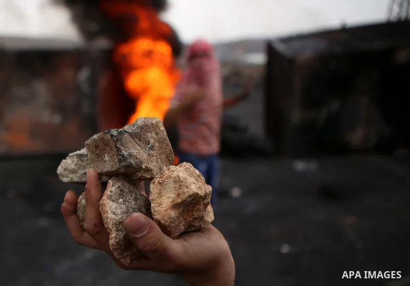 A Palestinian protester holds stones during clashes with Israeli security forces near the Jewish settlement of Beit El, near Ramallah on October 23, 2015. Palestinian factions called for mass rallies against Israel in th...