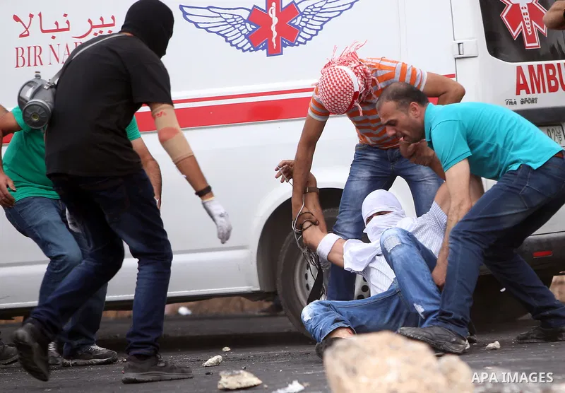 Palestinian protesters help an injured comrade during clashes with Israeli security forces near the Jewish settlement of Beit El, near Ramallah on October 23, 2015. Palestinian factions called for mass rallies against Is...