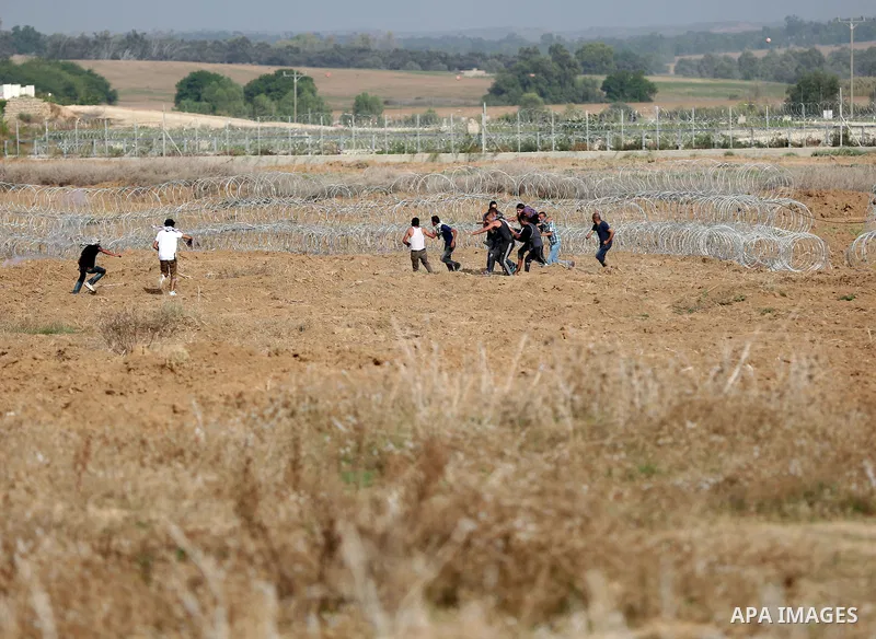 Palestinian protesters carry an injured comrade during clashes with Israeli security forces near the border between Israeli and central Gaza Strip, on October 23, 2015. Palestinian factions called for mass rallies agains...