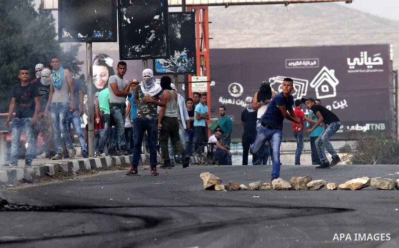 Palestinian youths throw stones during clashes with Israeli security forces at the Hawara checkpoint, south of the West Bank city of Nablus on October 22, 2015. Palestinian factions called for mass rallies against Israel...