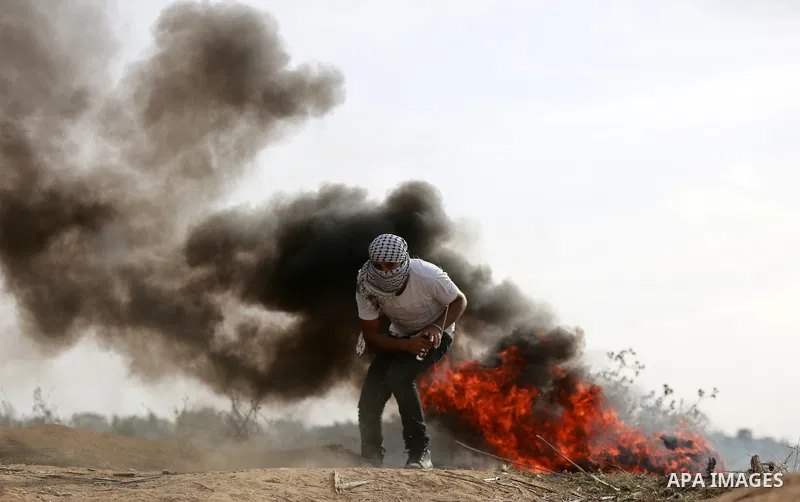 A Palestinian protester uses a sling shot to throw stones during clashes with Israeli security forces near the border between Israeli and central Gaza Strip, on October 23, 2015. Palestinian factions called for mass rall...