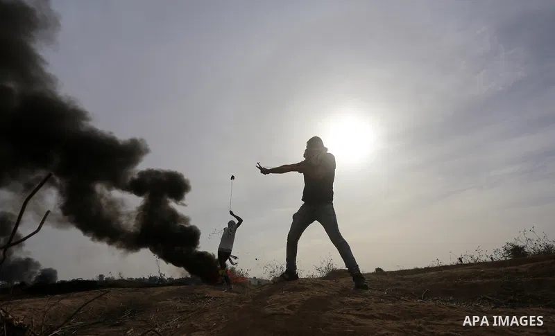 A Palestinian protester uses a sling shot to throw stones during clashes with Israeli security forces near the border between Israeli and central Gaza Strip, on October 23, 2015. Palestinian factions called for mass rall...