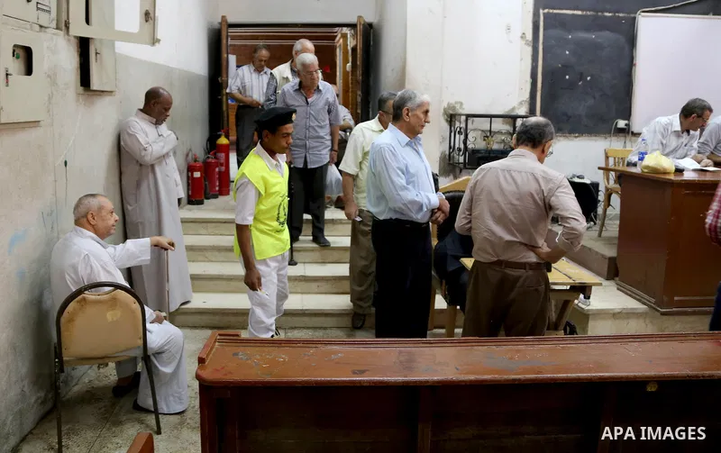 Egyptian men cast their ballot at a polling station in Cairo, as voters returned to polling stations on October 27, 2015 for a first round run-off in a parliamentary vote expected to elect lawmakers firmly backing Presid...