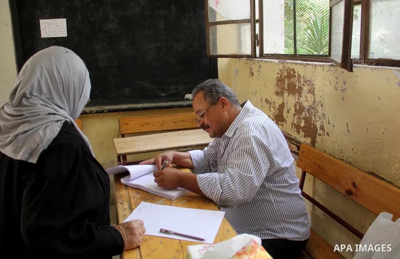 An Egyptian woman casts her ballot at a polling station in Cairo, as voters returned to polling stations on October 27, 2015 for a first round run-off in a parliamentary vote expected to elect lawmakers firmly backing Pr...