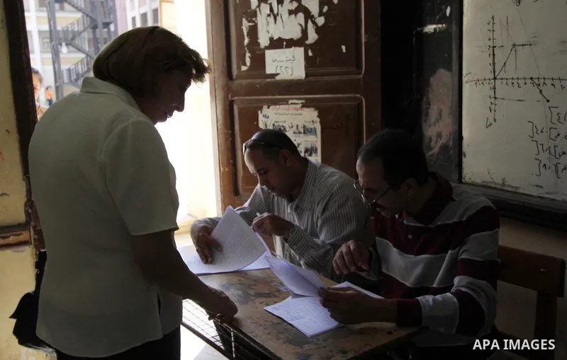 An Egyptian woman casts her ballot at a polling station in Cairo, as voters returned to polling stations on October 27, 2015 for a first round run-off in a parliamentary vote expected to elect lawmakers firmly backing Pr...
