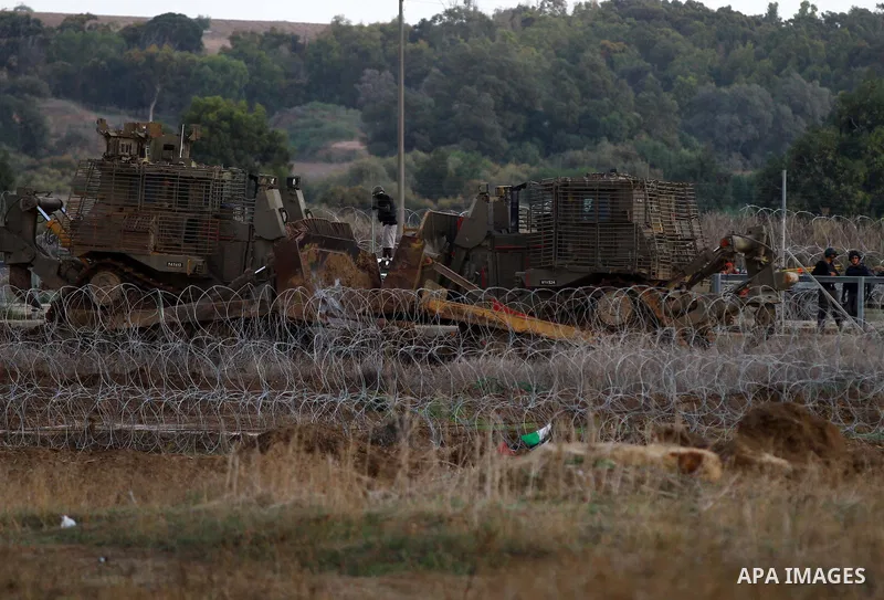 Israeli soldiers take position next to military bulldozers during clashes with Palestinian protesters near the border between Israel and Central Gaza Strip October 27, 2015. The current round of violence began last month...
