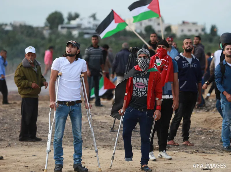 Palestinian protesters wave their national flags during clashes with Israeli troops near the border between Israel and Central Gaza Strip October 27, 2015. The current round of violence began last month with clashes at J...