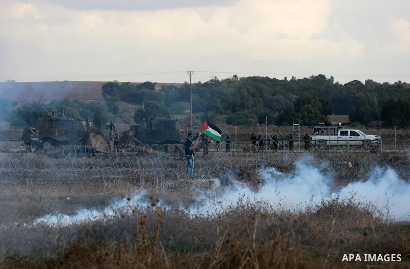 A Palestinian protester waves his national flag during clashes with Israeli troops near the border between Israel and Central Gaza Strip October 27, 2015. The current round of violence began last month with clashes at Je...