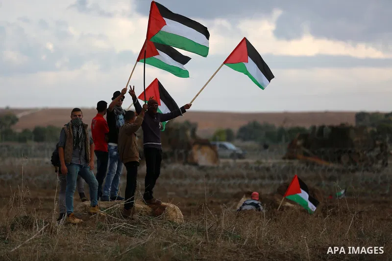 Palestinian protesters wave their national flags during clashes with Israeli troops near the border between Israel and Central Gaza Strip October 27, 2015. The current round of violence began last month with clashes at J...