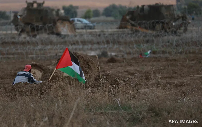 A Palestinian protester waves his national flag during clashes with Israeli troops near the border between Israel and Central Gaza Strip October 27, 2015. The current round of violence began last month with clashes at Je...