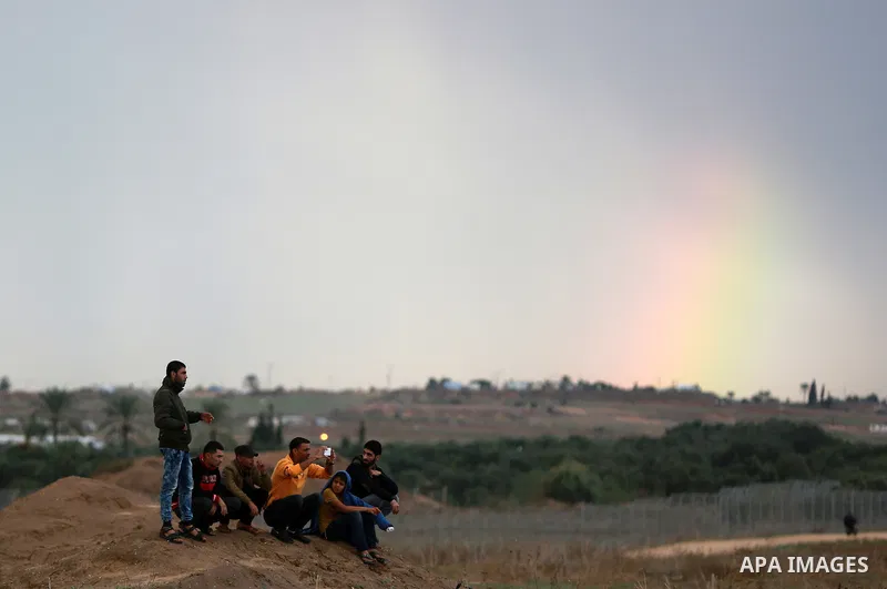 Rainbow is seen in the background as Palestinian protesters look on during clashes with Israeli troops near the border between Israel and Central Gaza Strip October 27, 2015. The current round of violence began last mont...