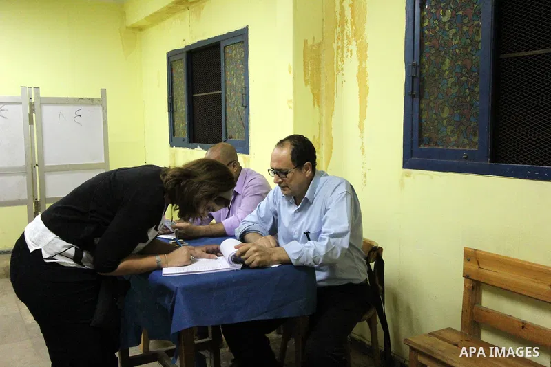 An Egyptian woman casts her ballot at a polling station in Cairo, as voters returned to polling stations on October 27, 2015 for a first round run-off in a parliamentary vote expected to elect lawmakers firmly backing Pr...