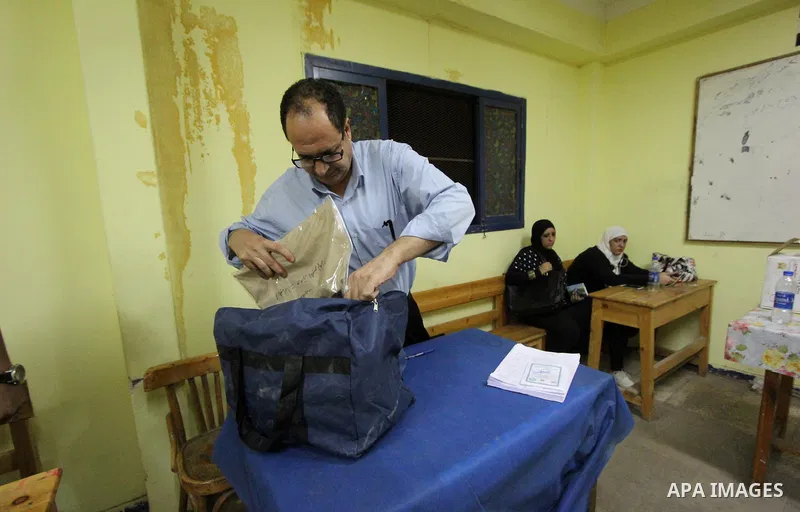 Egyptians official inspect boxes containing ballot cards for the Egyptian parliamentary elections at a polling station in Cairo, on October 18, 2015. for a first round run-off in a parliamentary vote expected to elect la...