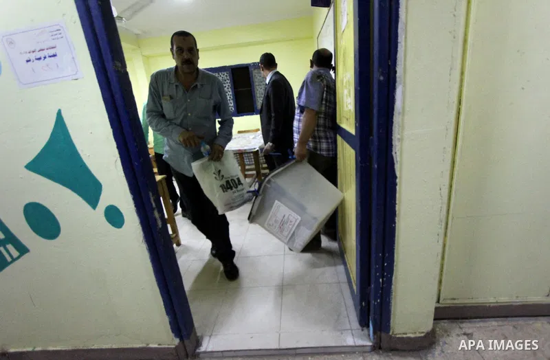 Egyptians official inspect boxes containing ballot cards for the Egyptian parliamentary elections at a polling station in Cairo, on October 18, 2015. for a first round run-off in a parliamentary vote expected to elect la...