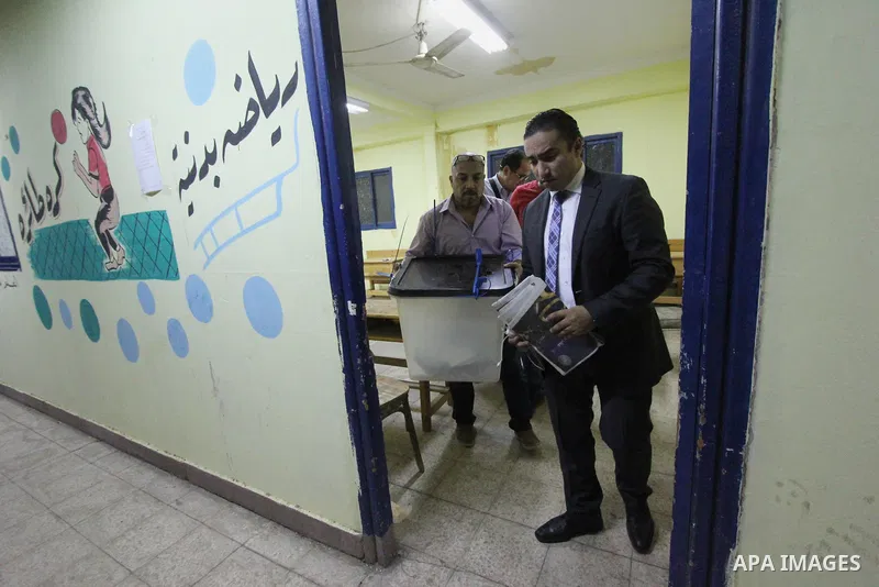 Egyptians official inspect boxes containing ballot cards for the Egyptian parliamentary elections at a polling station in Cairo, on October 18, 2015. for a first round run-off in a parliamentary vote expected to elect la...