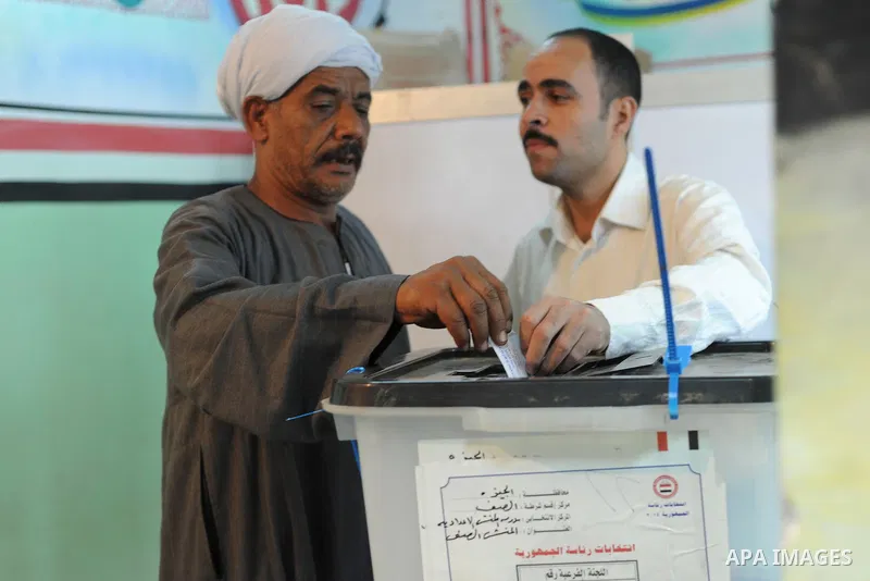 Egyptians cast their ballot at a polling station of the runoff to the first round of the parliamentary elections in Cairo, Egypt, Wednesday, Oct. 28, 2015. Photo by Amr Sayed