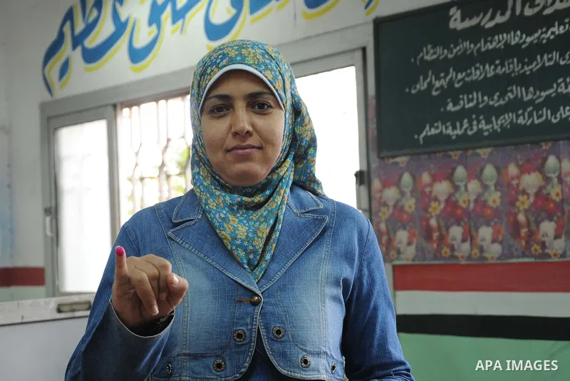 An Egyptian woman displays her inked finger after she casts her vote at a polling station of the runoff to the first round of the parliamentary elections in Cairo, Egypt, Wednesday, Oct. 28, 2015. Photo by Amr Sayed