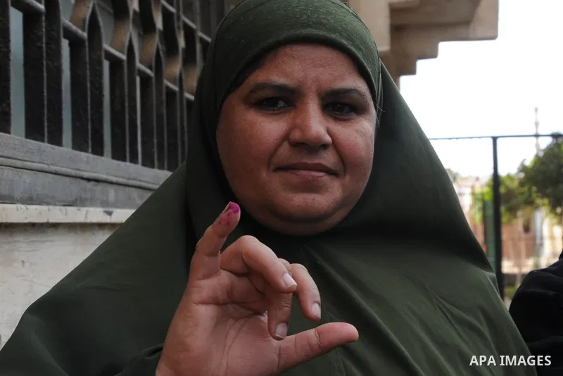 An Egyptian woman displays her inked finger after she casts her vote at a polling station of the runoff to the first round of the parliamentary elections in Cairo, Egypt, Wednesday, Oct. 28, 2015. Photo by Amr Sayed