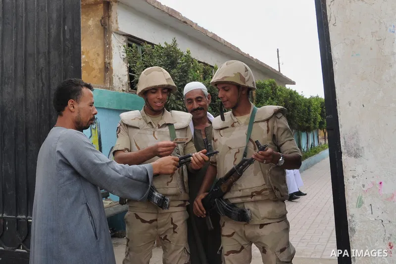 Egyptian soldiers stand guard at a polling station of the runoff to the first round of the parliamentary elections in Cairo, Egypt, Wednesday, Oct. 28, 2015. Photo by Amr Sayed