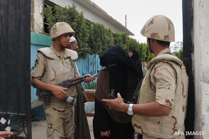Egyptian soldiers stand guard at a polling station of the runoff to the first round of the parliamentary elections in Cairo, Egypt, Wednesday, Oct. 28, 2015. Photo by Amr Sayed