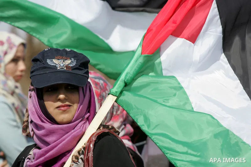 Palestinian demonstrators hold their national flag during an anti-Israel protest east of Khan Yunis, in the southern Gaza Strip, near a border fence with Israel, on October 28, 2015. Photo by Abed Rahim Khatib