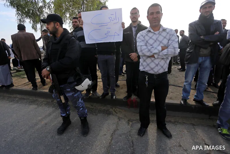 Palestinian teachers hold banners during a protest to demand their salaries, in Gaza City, on Oct. 29, 2015. Photo by Mohammed Asad