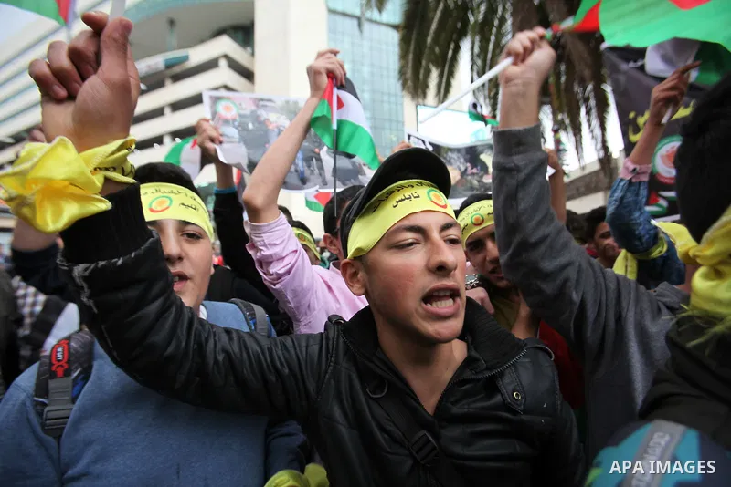Palestinian students hold National flags during a protest to demand their rights, in the west Bank city of Nablus, on Oct. 29, 2015. Photo by Nedal Eshtayah