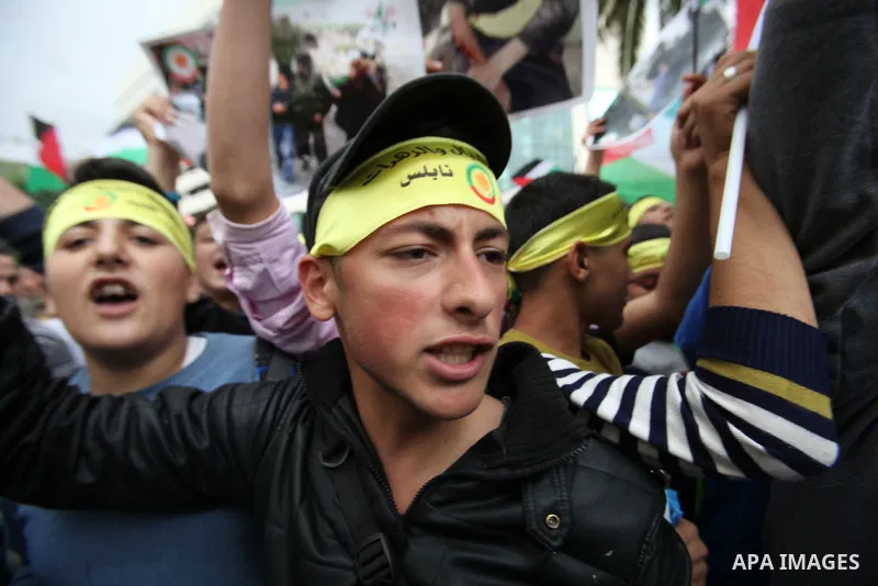 Palestinian students hold National flags during a protest to demand their rights, in the west Bank city of Nablus, on Oct. 29, 2015. Photo by Nedal Eshtayah